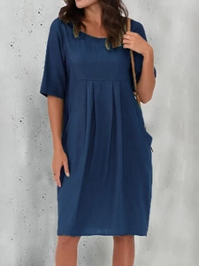 Detail view of navy blue cotton linen dress featuring pleated texture and round neckline