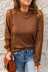 Detail of waffle knit fabric and floral lace hollow-out design on long puff sleeves