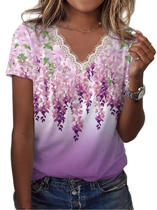 Dettaglio dello scollo a V con pizzo bianco sulla t-shirt estiva a stampa floreale