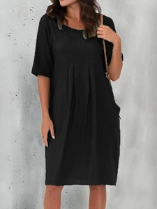 Detail of black cotton linen dress featuring pleated texture and functional side pockets