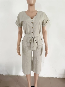 Détails de la combinaison en lin beige avec col en V, boutons et ceinture à nouer