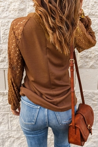 Detail of caramel brown waffle knit top featuring intricate lace patchwork sleeves
