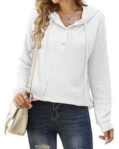 Détail d'un sweat à capuche blanc gaufré montrant l'encolure boutonnée et la maille