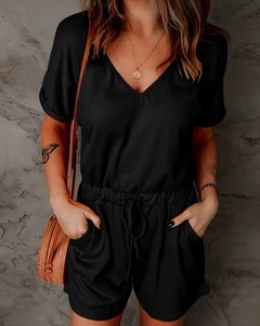 Detail of black V-neck jumpsuit showing ribbed texture fabric and drawstring waist
