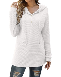 Détail de la maille gaufrée blanche et du col à boutons sur le pull à capuche