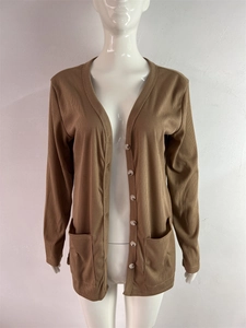Detail showing brown ribbed knit cardigan texture with front pockets and button closure