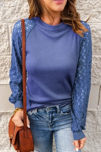 Detail of blue waffle knit top showing intricate lace sleeves and round neck texture