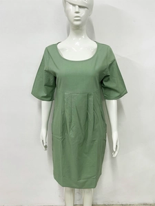 Detail view of green cotton linen dress featuring pleated waist and side pocket texture