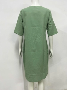 Rear view of green linen loose short sleeve dress showing pleated texture and fit