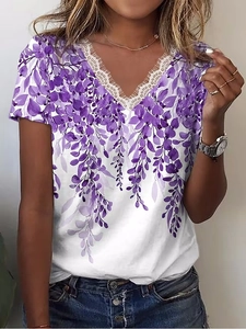 Dettaglio di t-shirt bianca con scollo a V, bordo in pizzo e stampa floreale viola