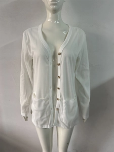 Detail of white ribbed knit cardigan featuring V-neck and brown marble-textured buttons