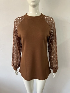 Detail of waffle knit fabric and circular lace patchwork on brown long sleeve shirt