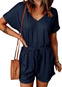 Detail of dark blue V-neck romper featuring textured waffle knit fabric and drawstring waist