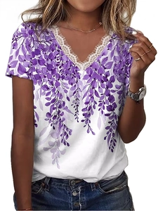 Dettaglio dello scollo a V in pizzo e stampa floreale viola su t-shirt estiva bianca
