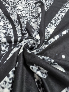Macro shot of thick fabric showing black and white leopard print with animal textures