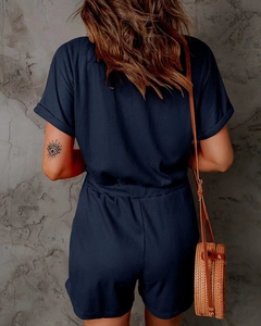 Back view of navy blue ribbed knit short jumpsuit showing waist elastic and texture