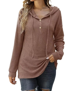 Vue détaillée du tricot gaufré et des boutons en bois sur ce pull à capuche à manches longues