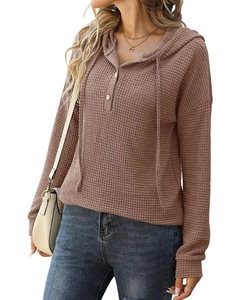 Détail du tissu gaufré et du col à boutons sur un sweat à capuche marron décontracté