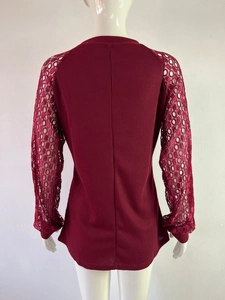 Detail showing red waffle knit top with intricate floral lace crochet long sleeves