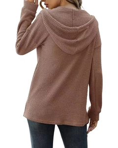 Détail de la texture en maille gaufrée rose et de la capuche de ce pull décontracté pour femme