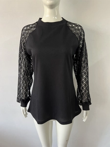 Close-up of black waffle knit texture and floral lace stitching on long sleeve top