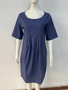 Detail view of the round neckline and pleat texture on navy blue linen dress
