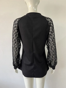 Detail of waffle knit fabric and lace patchwork sleeves on black women's long sleeve top