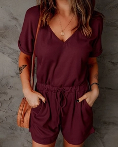 Detail of burgundy V-neck romper featuring ribbed knit fabric and waist drawstring