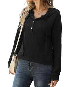 Détail de la maille gaufrée noire sur ce pull à capuche pour femme avec boutons col V
