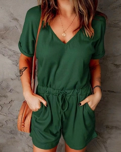 Detail shot of dark green ribbed knit jumpsuit featuring a V-neck and drawstring waist