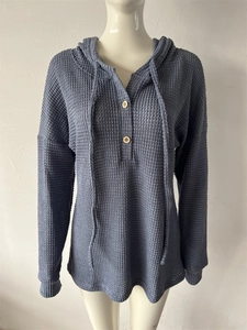 Détail du sweat à capuche en maille gaufrée bleu marine avec boutons en bois et cordon