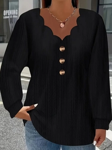 Close-up of black scalloped V-neck top showing ribbed texture and decorative buttons