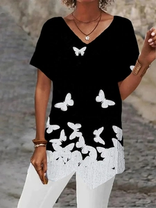 Detail of V-neck women's black tee featuring a white butterfly print and asymmetric hem