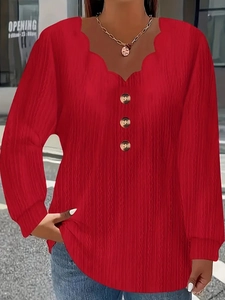 Close-up of scallop V-neckline with buttons on a red ribbed knit long sleeve top