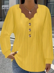 Close-up of wavy V-neck with buttons and plissé texture on yellow long sleeve top