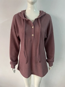 Détail macro de la maille gaufrée sur le sweat à capuche mauve avec boutons en bois