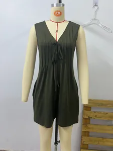 Detail of olive green sleeveless romper featuring V-neckline with ties and pleated bodice