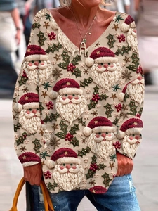 Close-up of women's V-neck long sleeve top with festive Santa Claus and holly berry print