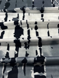 Detail of V-neck long sleeve dress fabric featuring grey tie-dye ink stripe pattern