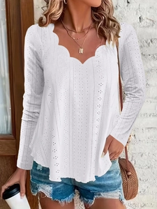 Detail of white long sleeve top featuring scalloped V-neckline and eyelet embroidery pattern