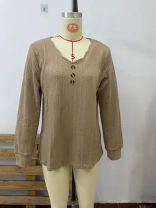 Detail of scallop V-neckline and button design on a brown ribbed knit long sleeve top