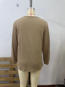 Detailed cable knit texture and snug cuffs on a brown long-sleeved winter sweater