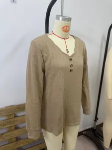 Close-up of a khaki V-neck knit top with cable stitch details and decorative buttons