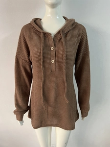 Détail du sweat à capuche en maille gaufrée marron avec cordon et boutons