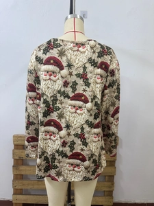 Detail of Santa Claus print on cream long sleeve top with festive berry patterns