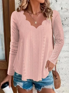 Detail of scalloped V-neckline and intricate eyelet pattern on pink long sleeve top