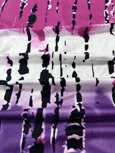 Detailed macro view of tie-dye knit fabric with pink and purple gradient and ink spots