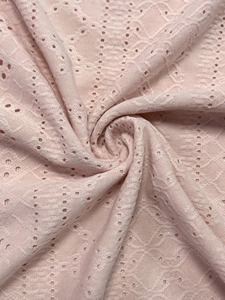 Close-up of pink knit top featuring scallop neck texture and hollow jacquard pattern