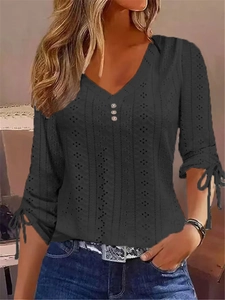 Elegant black V-neck top with geometric eyelet pattern and bow tie cuff details