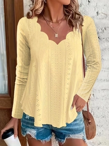 Detail of light yellow knit top featuring scallop neckline and hollow eyelet pattern